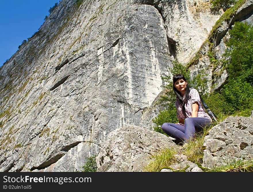 Woman sitting at the edge of a cliff. Woman sitting at the edge of a cliff