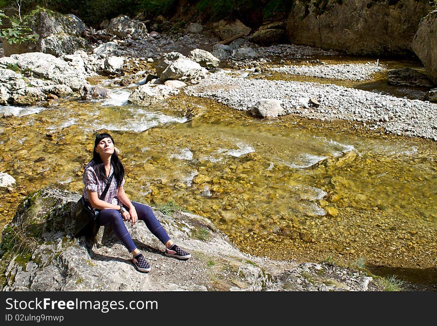 Woman sun bathing near a mountain river. Woman sun bathing near a mountain river