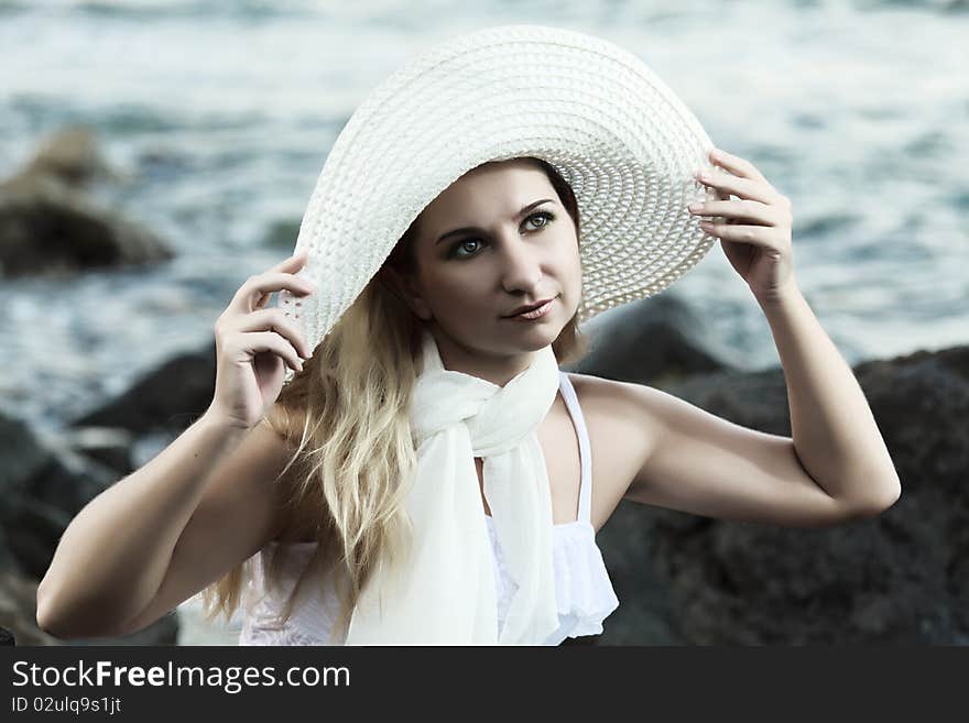 Young beautiful woman posing near the ocean. Young beautiful woman posing near the ocean