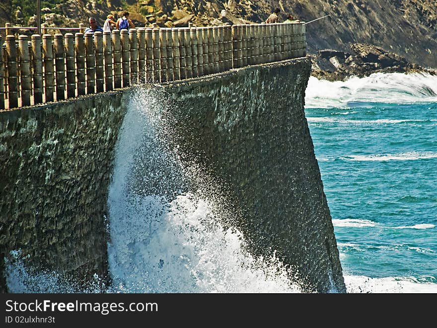 Water arrives at the border and brake up very hard against rocs. In th background we can see ocean and other rocs. Water arrives at the border and brake up very hard against rocs. In th background we can see ocean and other rocs.