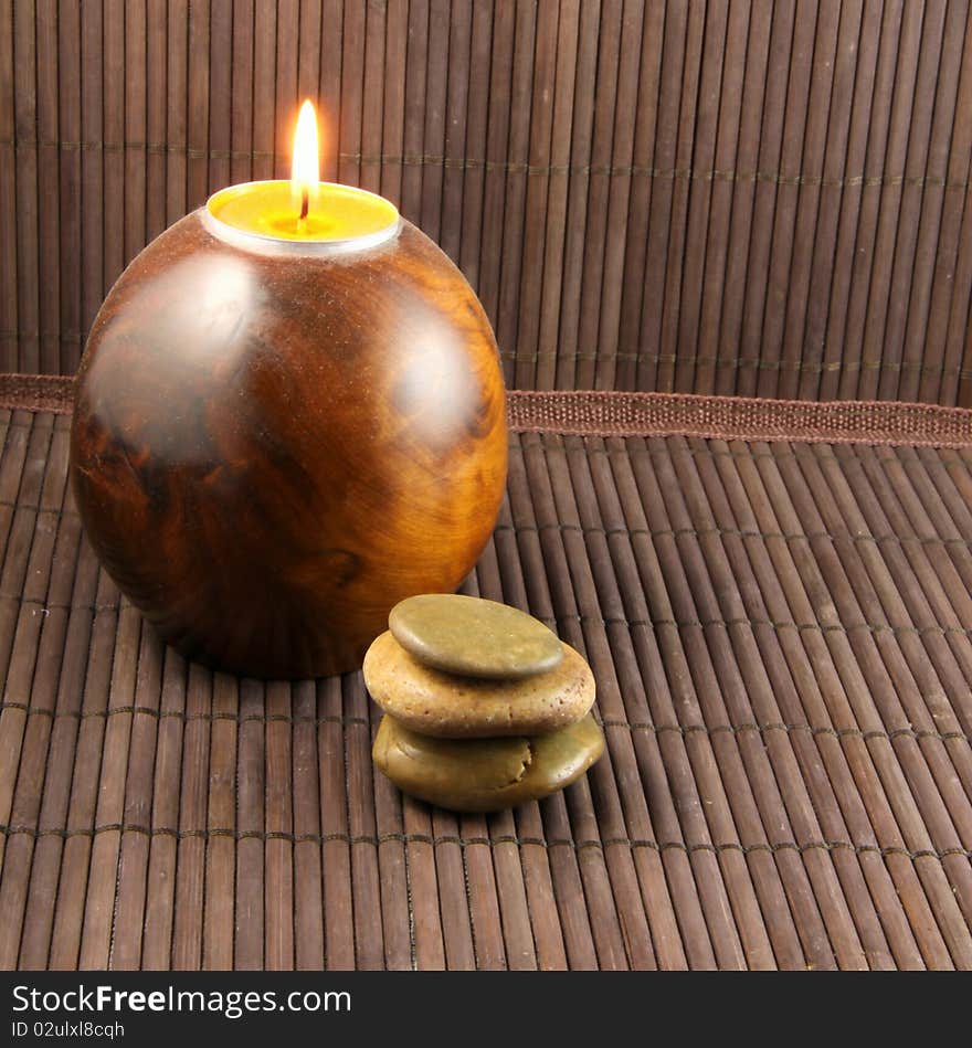 Zen atmosphere with candle, pebbles and bamboo