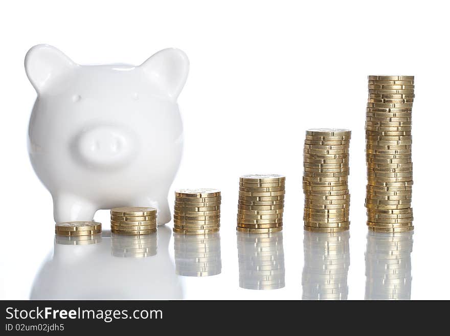 A Piggy Bank is standing behind some stack of coins