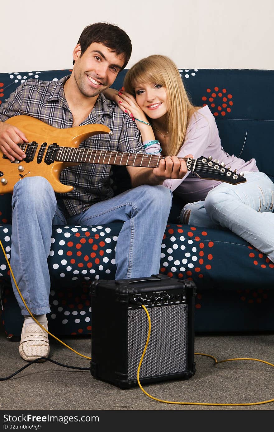 Romantic young couple resting on a sofa with a music