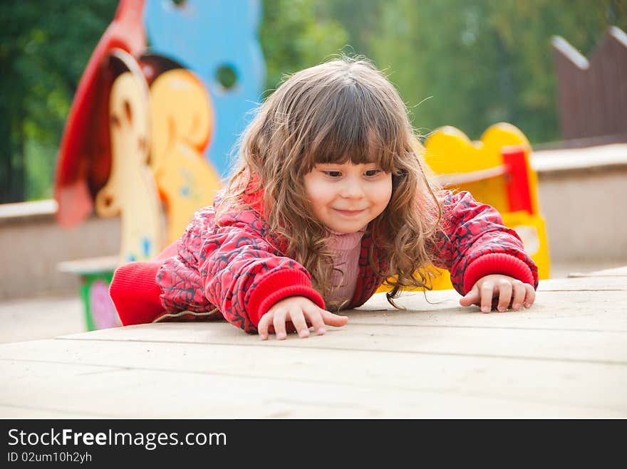 Little girl plays in playground in a park