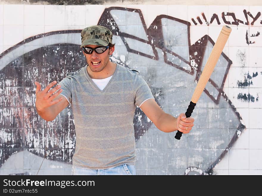 A aggressive man with a stick in a hand