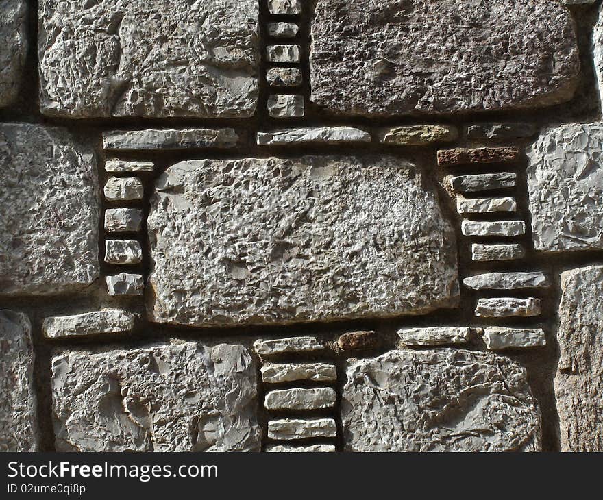 A house wall made of different piece of stones. A house wall made of different piece of stones