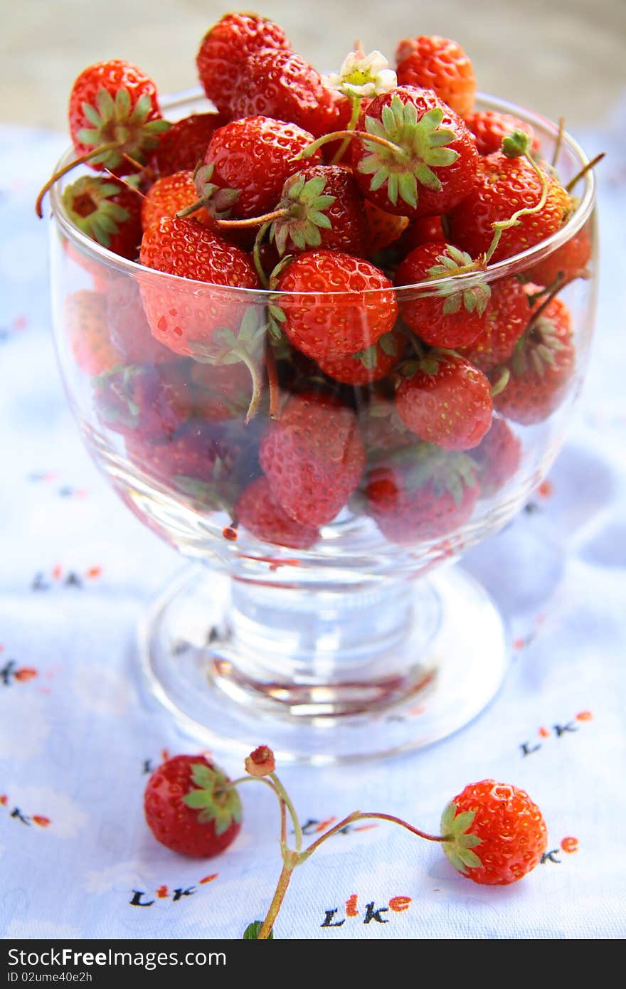 A lot of strawberries in a bowl on the table. A lot of strawberries in a bowl on the table