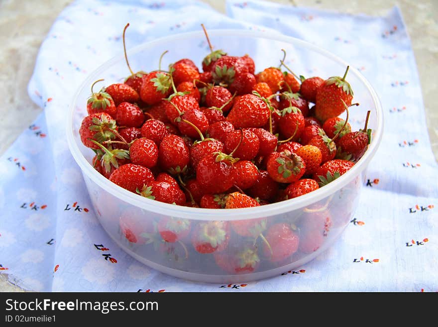 A lot of strawberries in a bowl on the table. A lot of strawberries in a bowl on the table