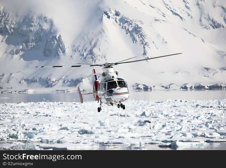 Helicopter in action over the frozen Arctic fjord, Spitsbergen