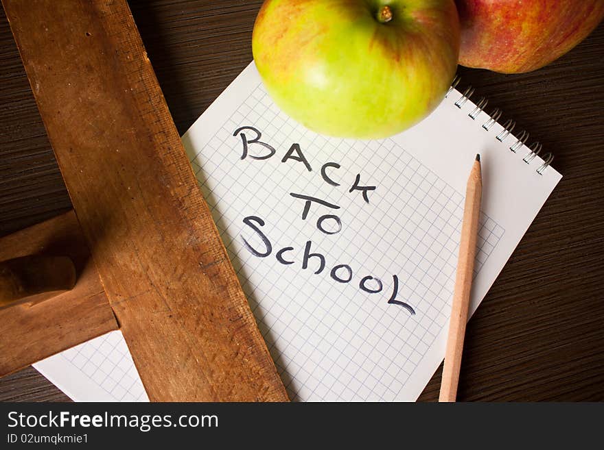 Spiral notebook with apples on table. Spiral notebook with apples on table