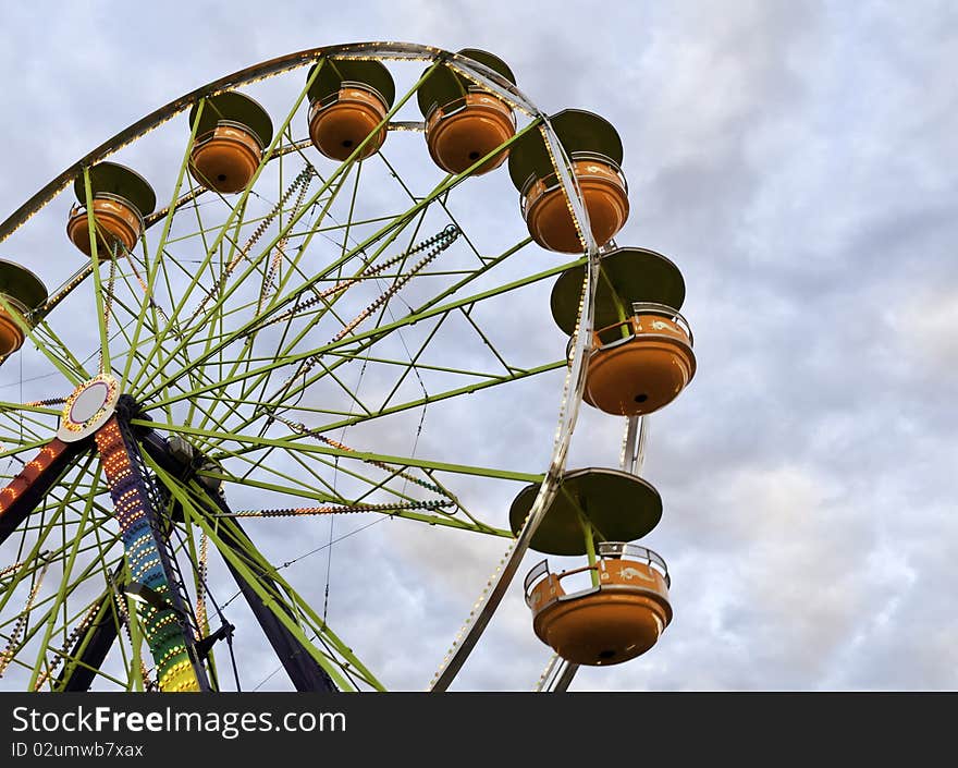 A Freeis Wheel at a county fair against a colorful evening sky. A Freeis Wheel at a county fair against a colorful evening sky.