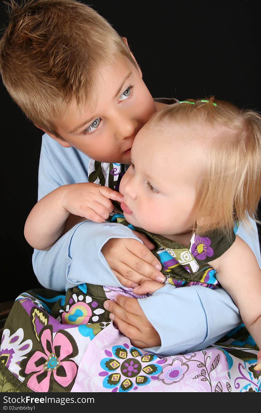 Cute brother holding his toddler sister in his arms. Cute brother holding his toddler sister in his arms