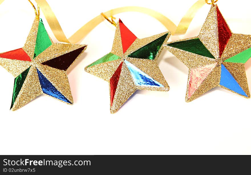 String of three glittering Christmas star ornaments on white with copy space below. String of three glittering Christmas star ornaments on white with copy space below.