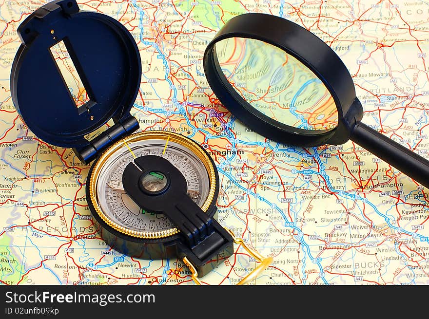 Compass and magnifier on a map for travel by close up. Compass and magnifier on a map for travel by close up