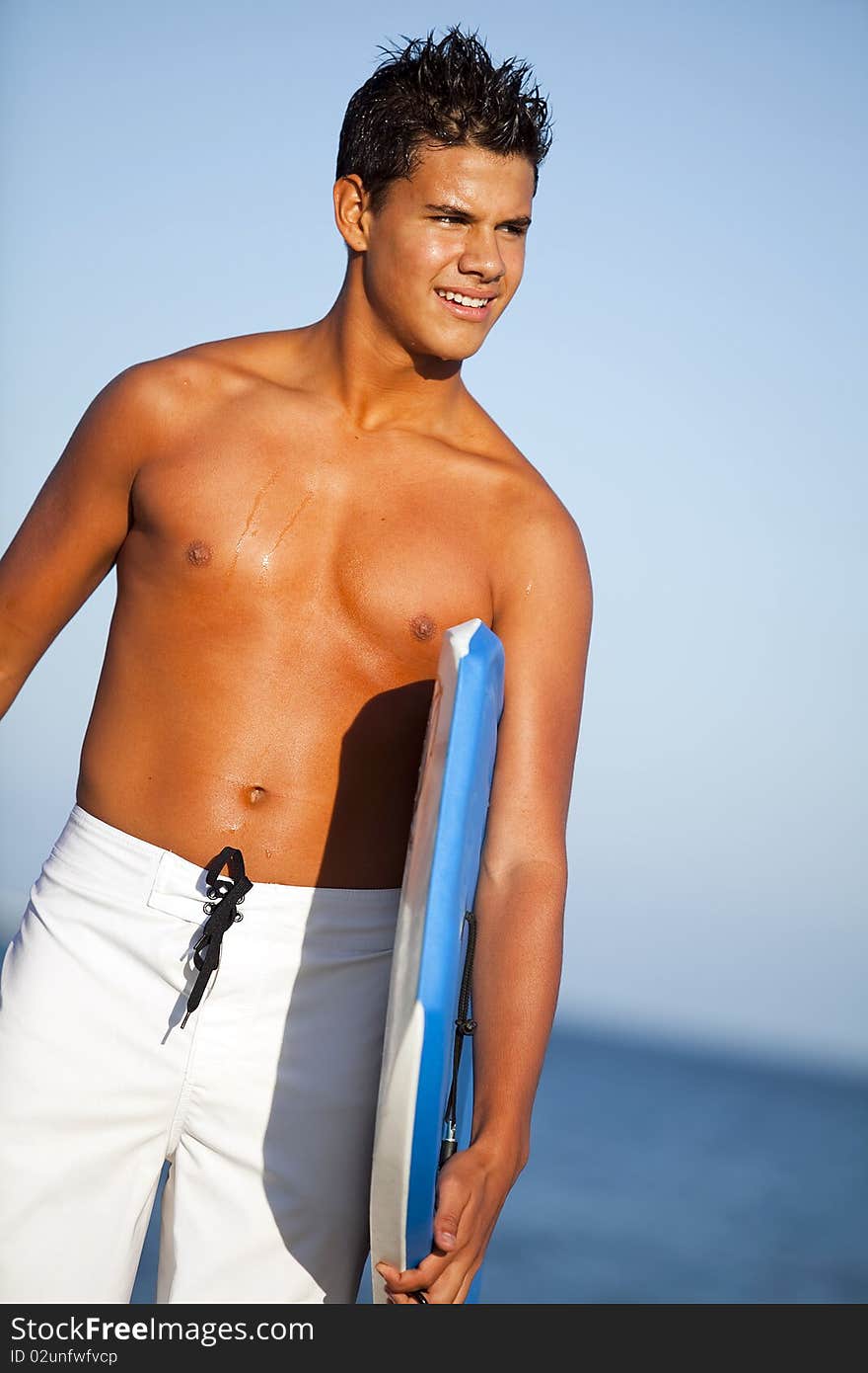 Young man at the beach with a boogie board. Young man at the beach with a boogie board