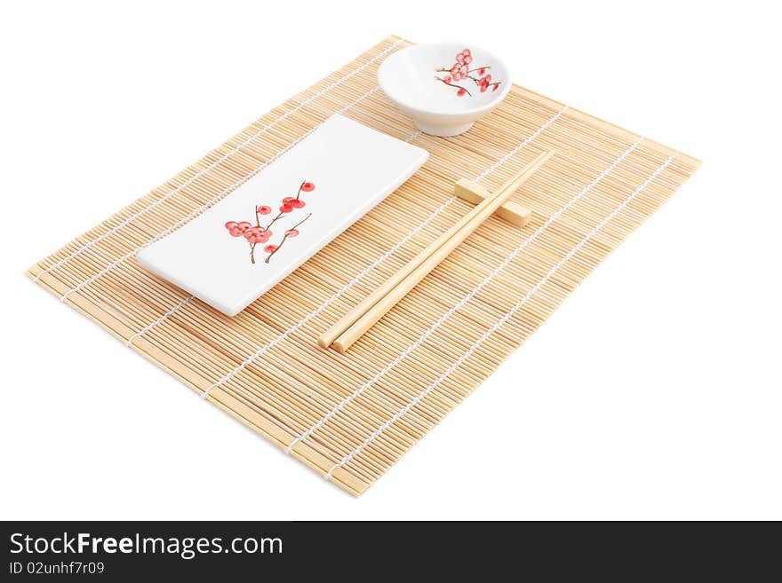 Sushi Plates And Chopsticks On Bamboo Mat