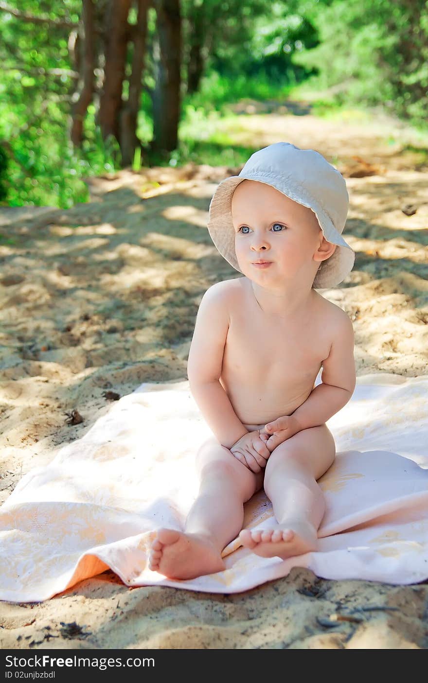 A little boy sitting on the sand