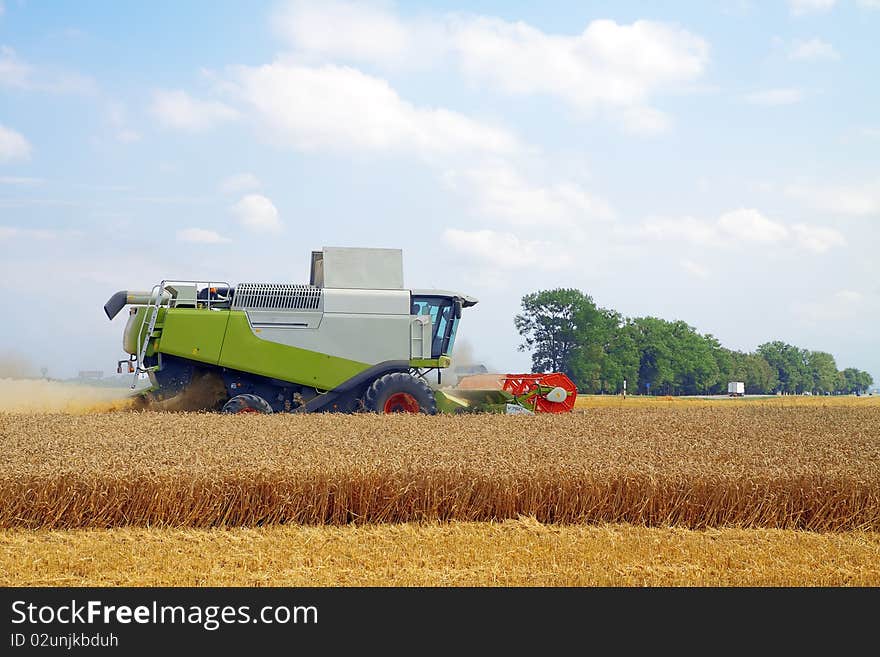 Modern combine harvester working on a wheat crop. Modern combine harvester working on a wheat crop