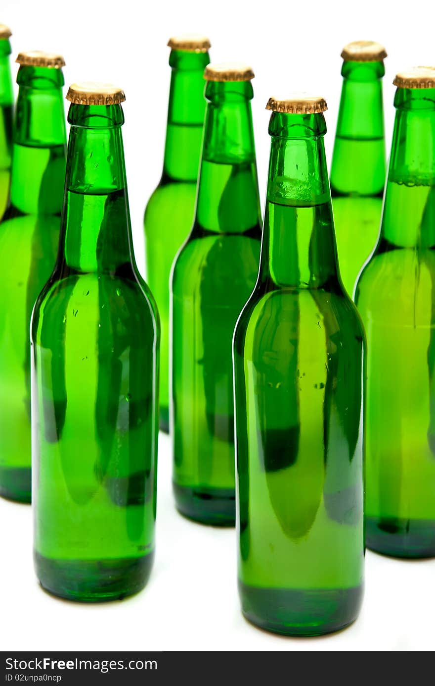 Rows from cold beer bottles on white background.