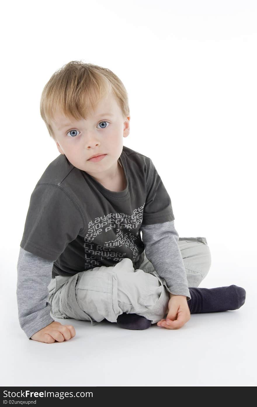 Boy sitting on white background.