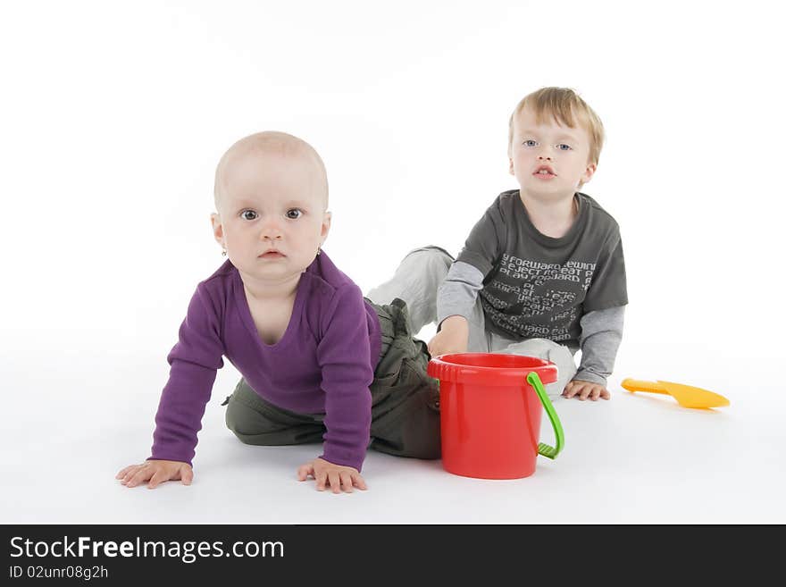 Boy and little girl with pail and shovel on white background.