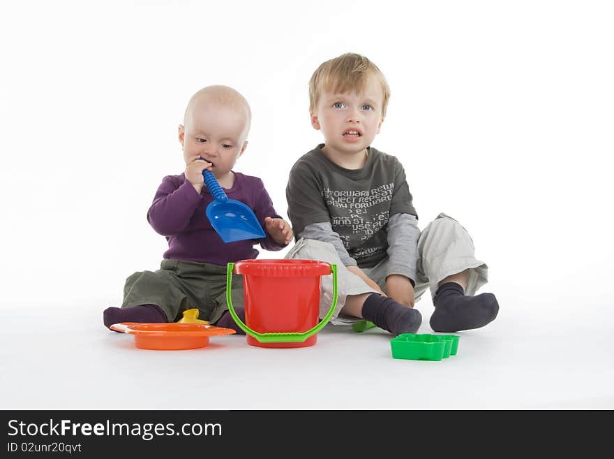 Boy and little girl with pail and shovel on white background.