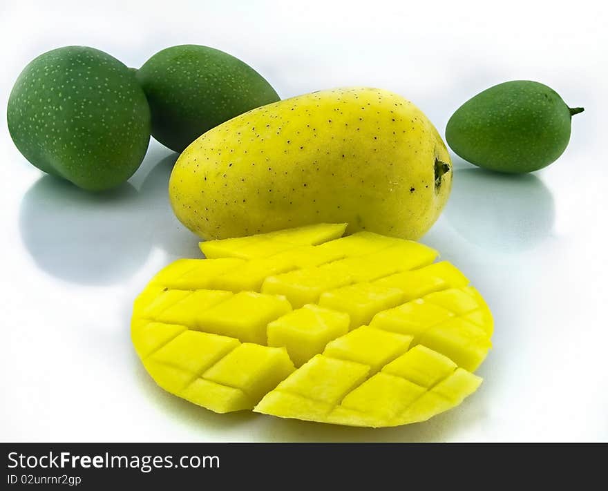 Mango with section along with unripe mango on white