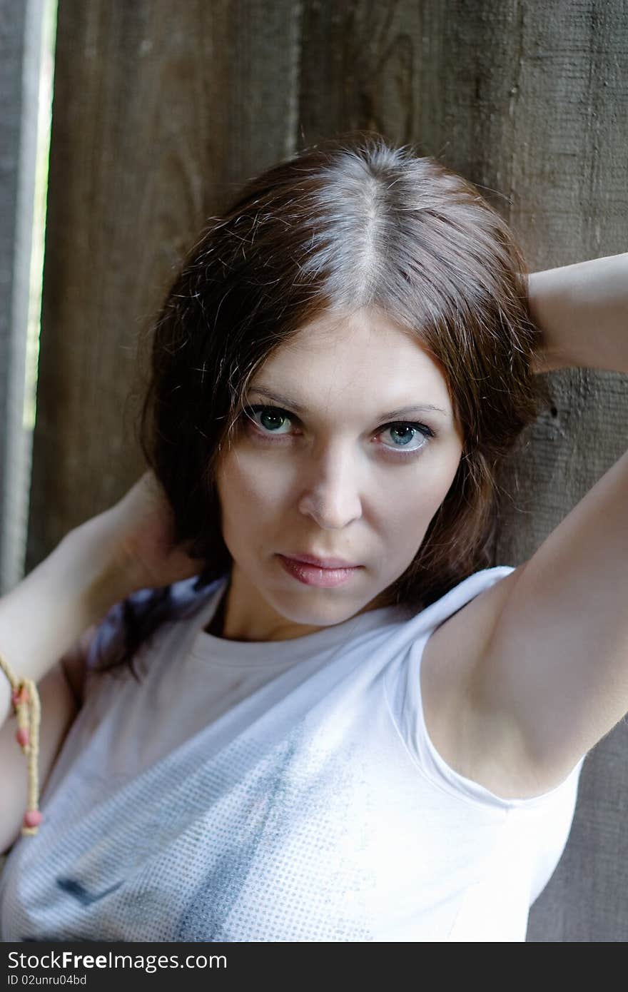 Close-up of beautiful woman against a old wooden wall. Close-up of beautiful woman against a old wooden wall