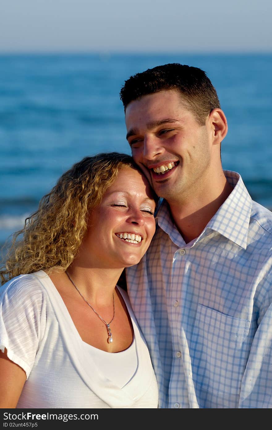 Happy smiling couple. The couple is standing on beach.