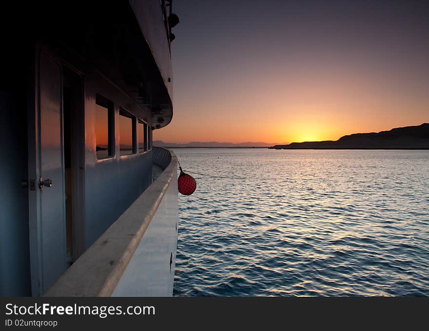 Sunset over the sea reflected in the windows of a boat. Sunset over the sea reflected in the windows of a boat