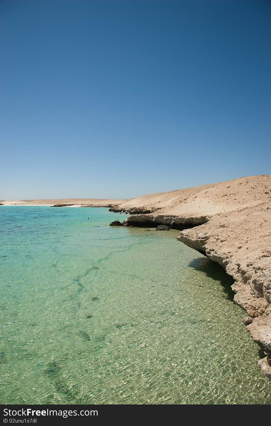 Turquoise waters and gentle waves of a golden sand beach with deep blue sky. Turquoise waters and gentle waves of a golden sand beach with deep blue sky.