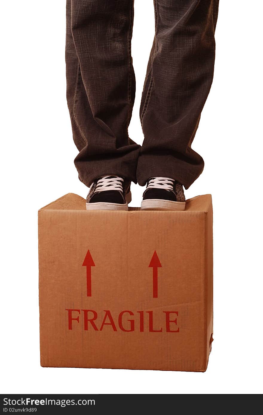 A concept image of a man standing on a box labelled fragile. A concept image of a man standing on a box labelled fragile