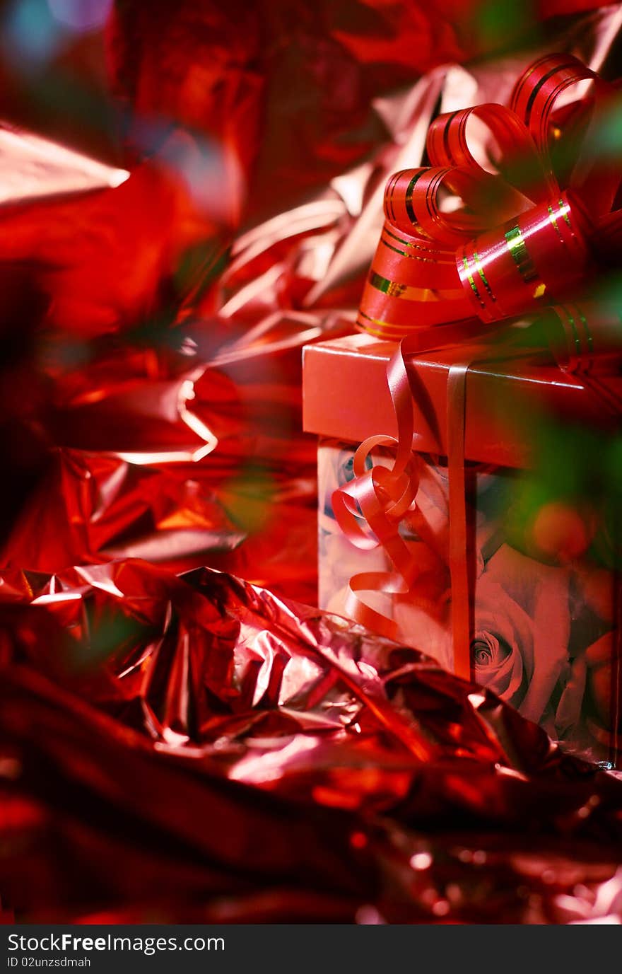 Gift with a red bow against a shining paper. Gift with a red bow against a shining paper