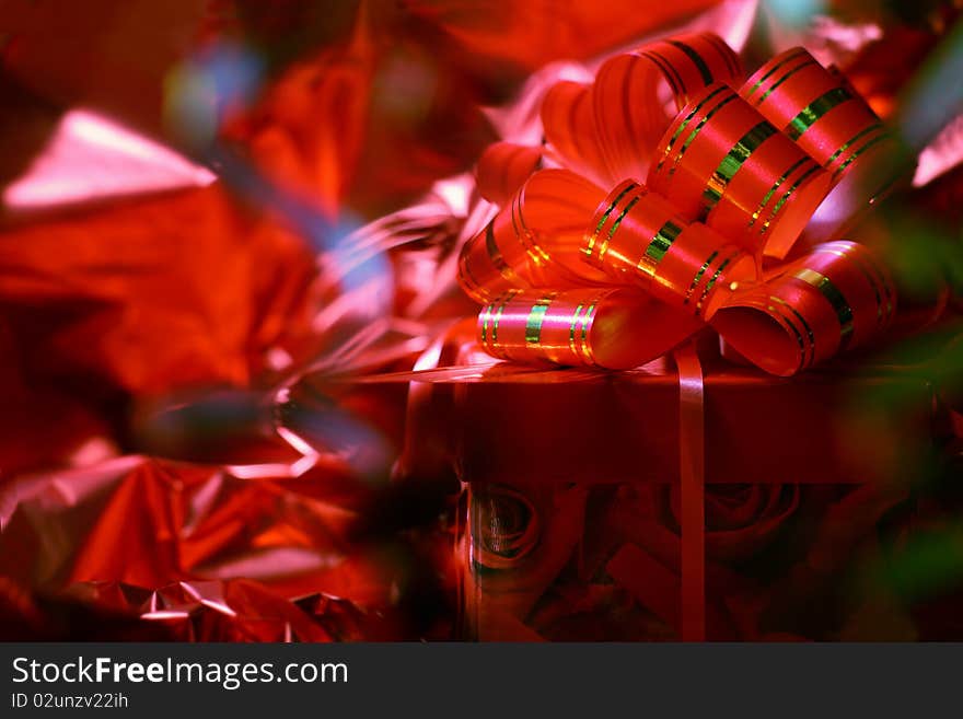 Gift with a red bow against a shining paper. Gift with a red bow against a shining paper