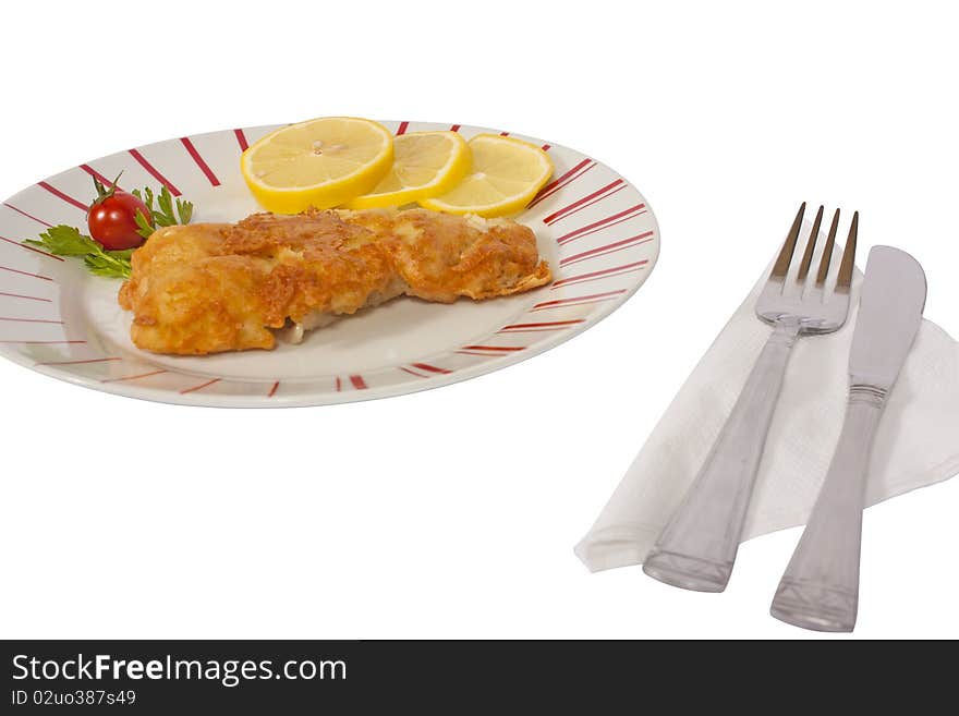 Fish schnitzel with lemon on a plate isolated on white background