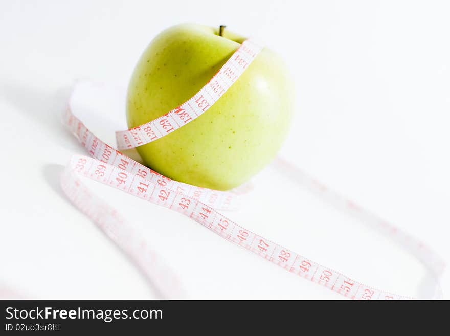 Green apple and measure tape, dieting theme