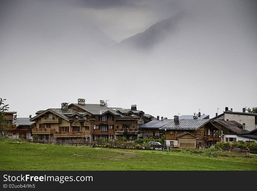 This image shows a view of the idyllic village of Le Praz, the mountain looming in the mist. This image shows a view of the idyllic village of Le Praz, the mountain looming in the mist