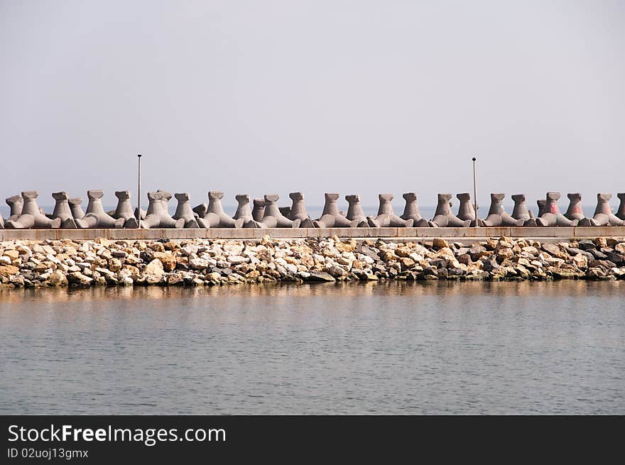 Breakwater dam made of concrete at the seashore.