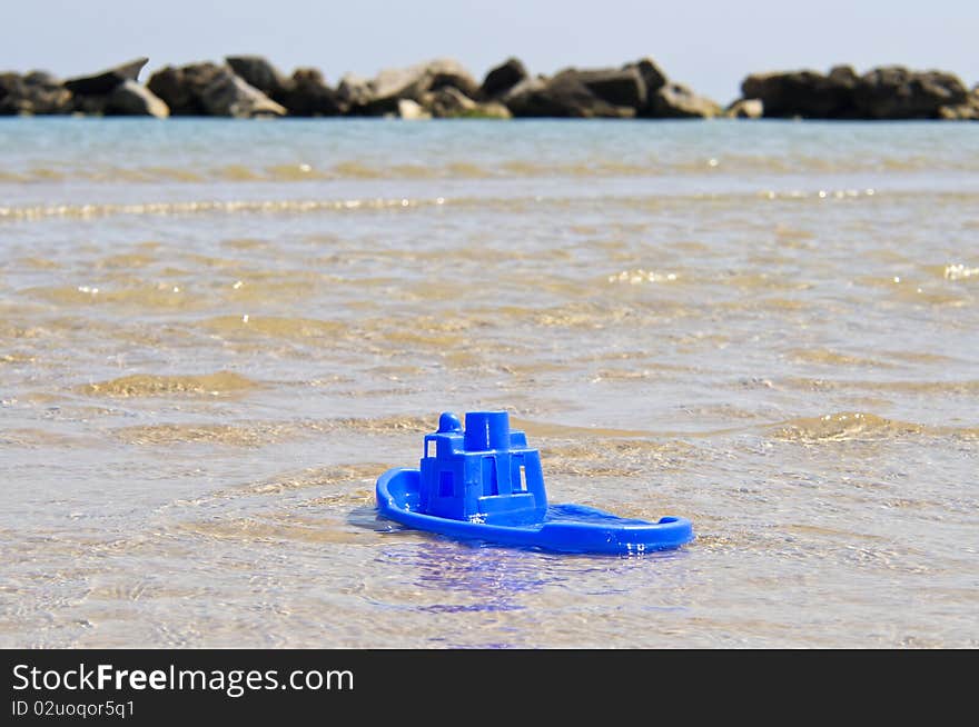 Small boat made of blue plastic in the sea. Small boat made of blue plastic in the sea