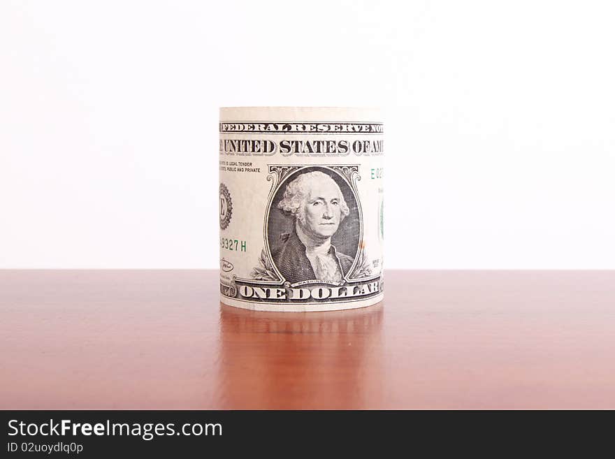 One dollar roll on wooden surface. Money concept image