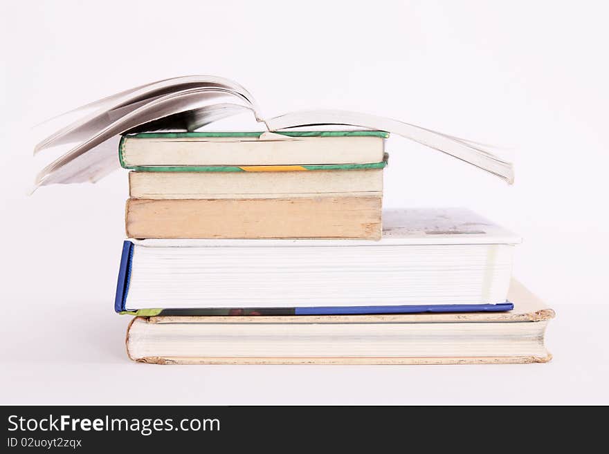 Old books with one open on white background. Old books with one open on white background