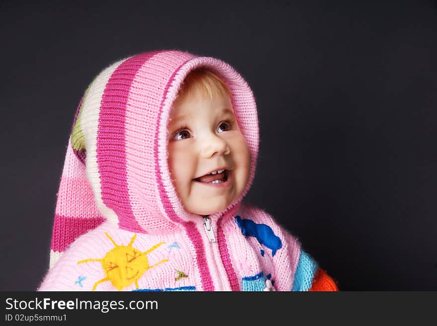 Portrait of hahhy smiling baby in hood looking up, studio shot. Portrait of hahhy smiling baby in hood looking up, studio shot