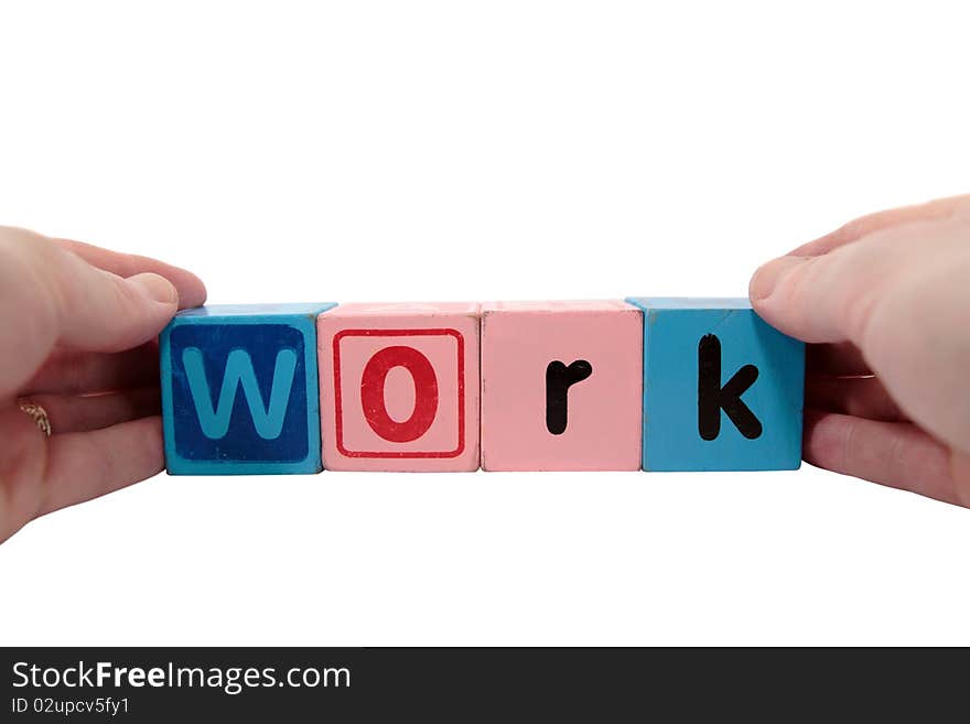 Toy letters that spell work held with hands against a white background with clipping path. Toy letters that spell work held with hands against a white background with clipping path