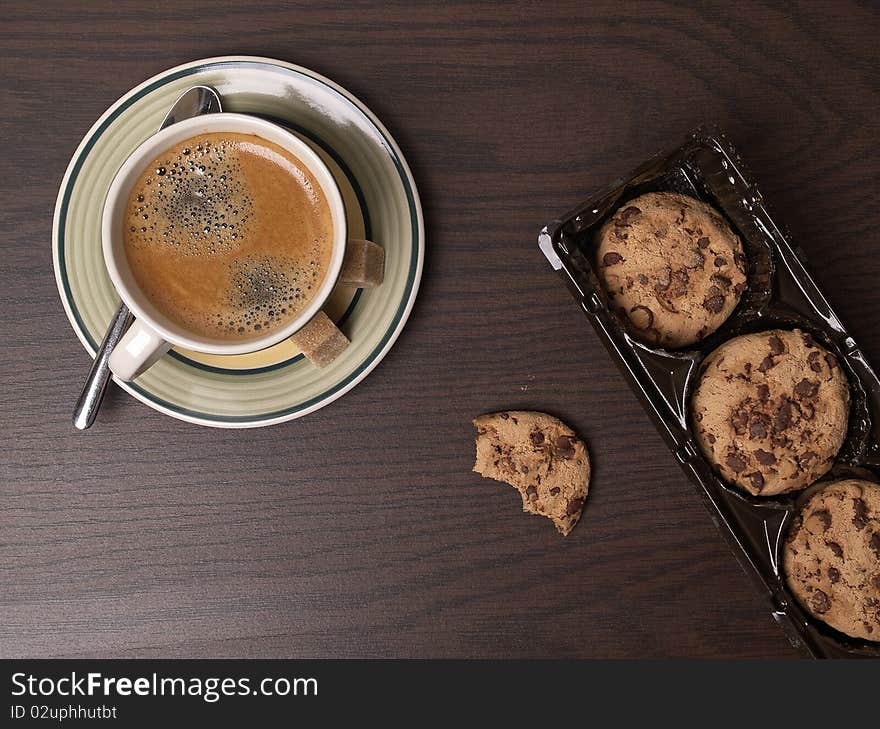 The photo shows some cookies and a cup of coffee on a table