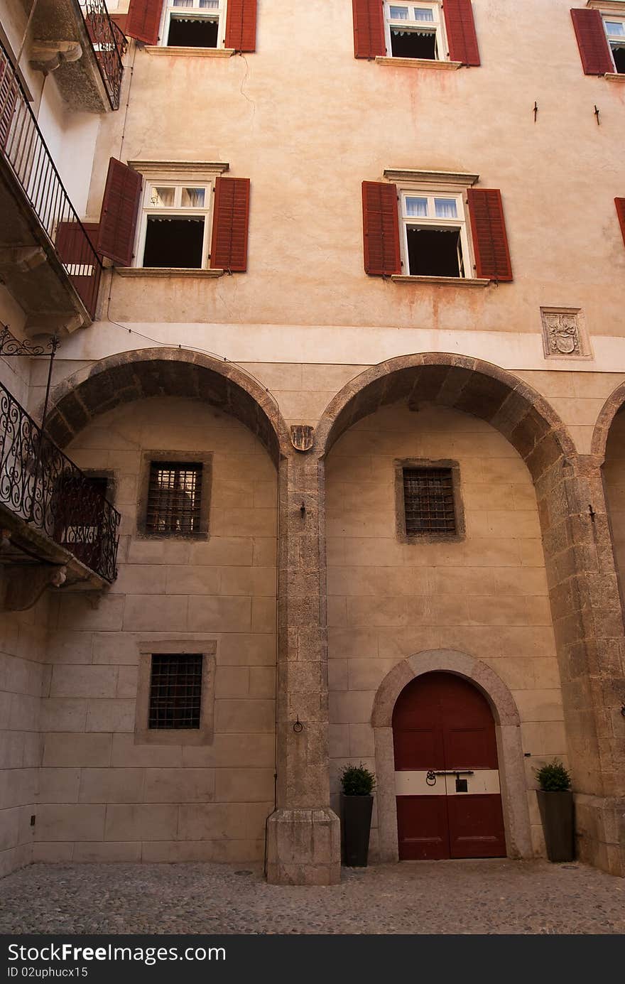 Courtyard of Castel Thun windows with rocks and a pit on the floor