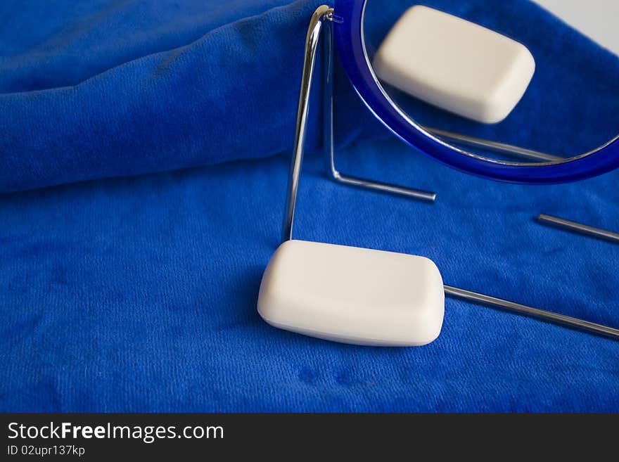 Mirror and soap on blue bath towel. Mirror and soap on blue bath towel