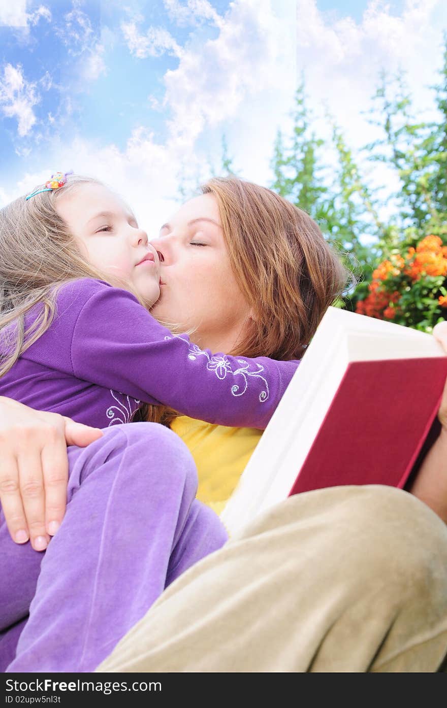 Kiss mother and daughter in the yard. Kiss mother and daughter in the yard