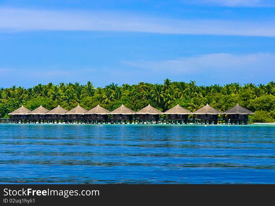 Water bungalows on a tropical island - travel background