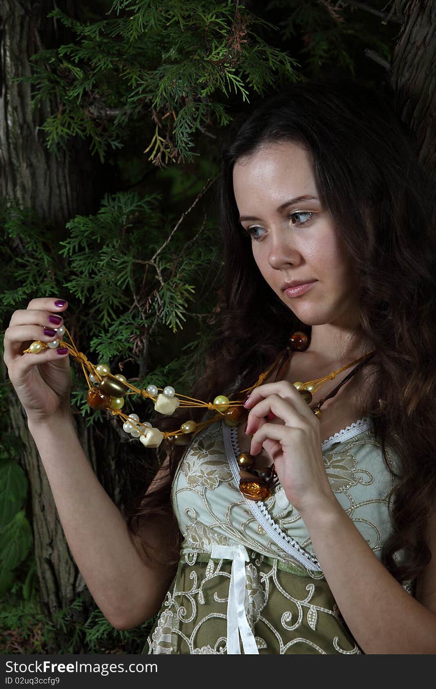 Attractive young women in the wood look at a beads. Attractive young women in the wood look at a beads