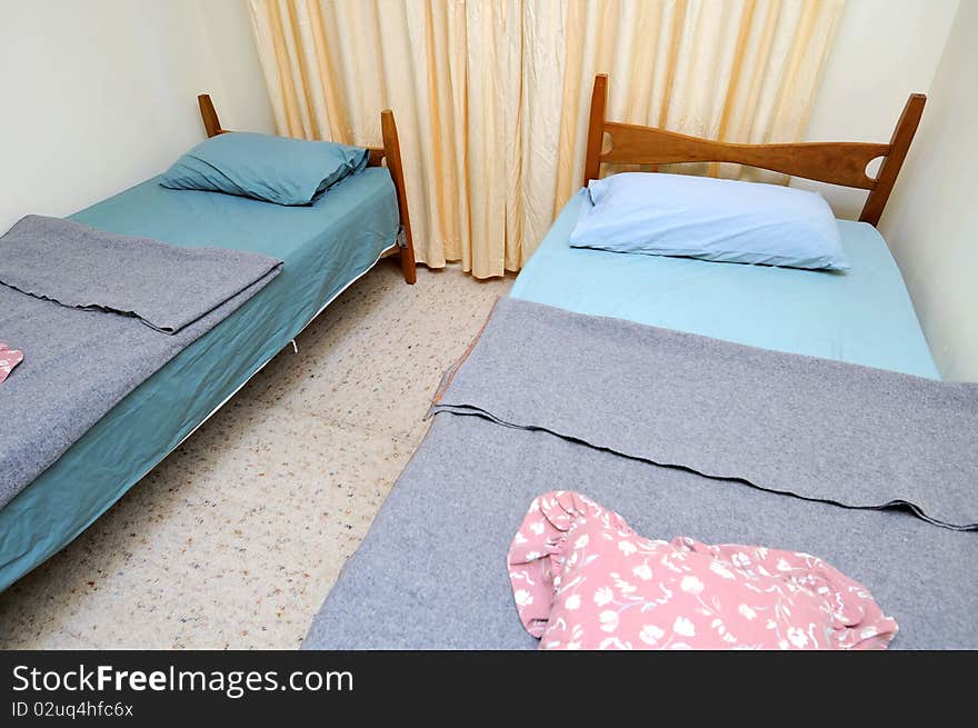 Twin beds in simple motel room. Suitable for concepts such as budget travel, tourism, vacation and holiday, and relaxation.